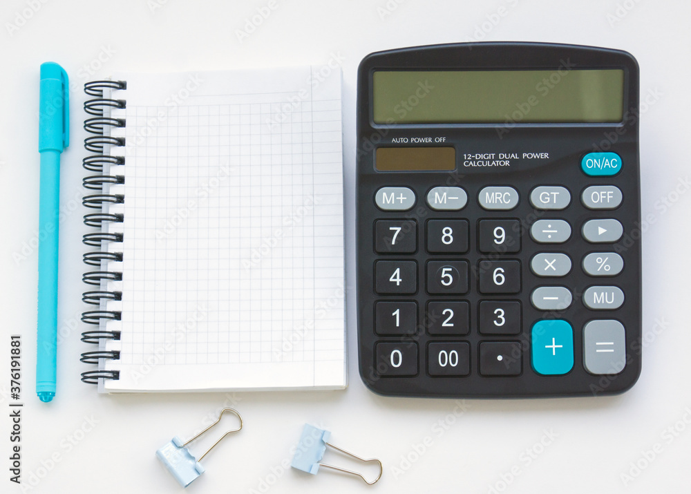 The calculator is on the table, next to an open empty notebook and a turquoise pen. Illustration of financial notes and mathematical calculations The calculator is on the table, next to an open empty notebook and a turquoise pen. Illustration of financial notes and mathematical calculations
