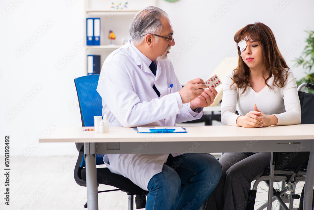 Young woman visiting old male doctor ophthalmologist Young woman visiting old male doctor ophthalmologist
