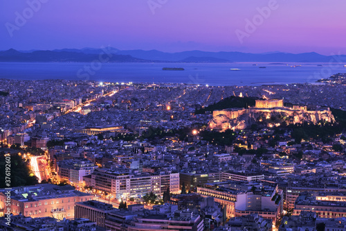 Panoramic view of Athens and Acropolis shot from Lycabettus hill. Parthenon lit up by night lights. Famous iconic view of UNESCO world heritage site. © NPershaj
