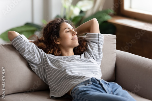 Εκτύπωση καμβά Peaceful young woman relaxing alone in cozy living room leaned on sofa cushion b