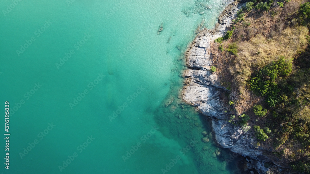 Aerial view. Top view of turquoise sea water washes the rocky shore in Thailand. Landscape background