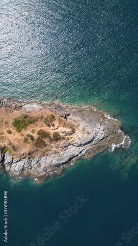 Vertical orientation aerial view. Top view of the peninsula in the middle of the sea, washed by clear turquoise water. Thailand