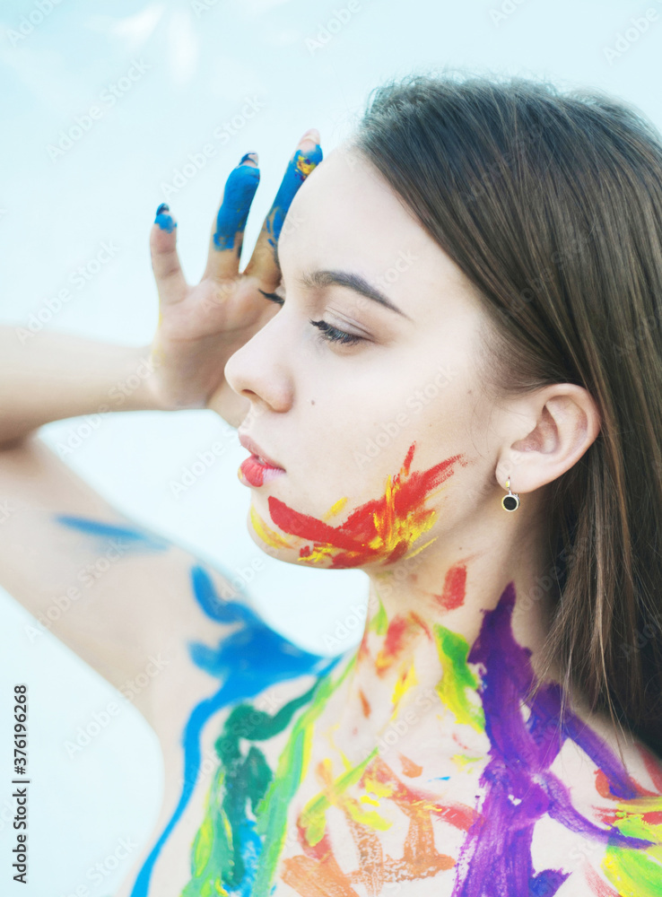 Obraz premium Close up portrait of young woman with paints on the face