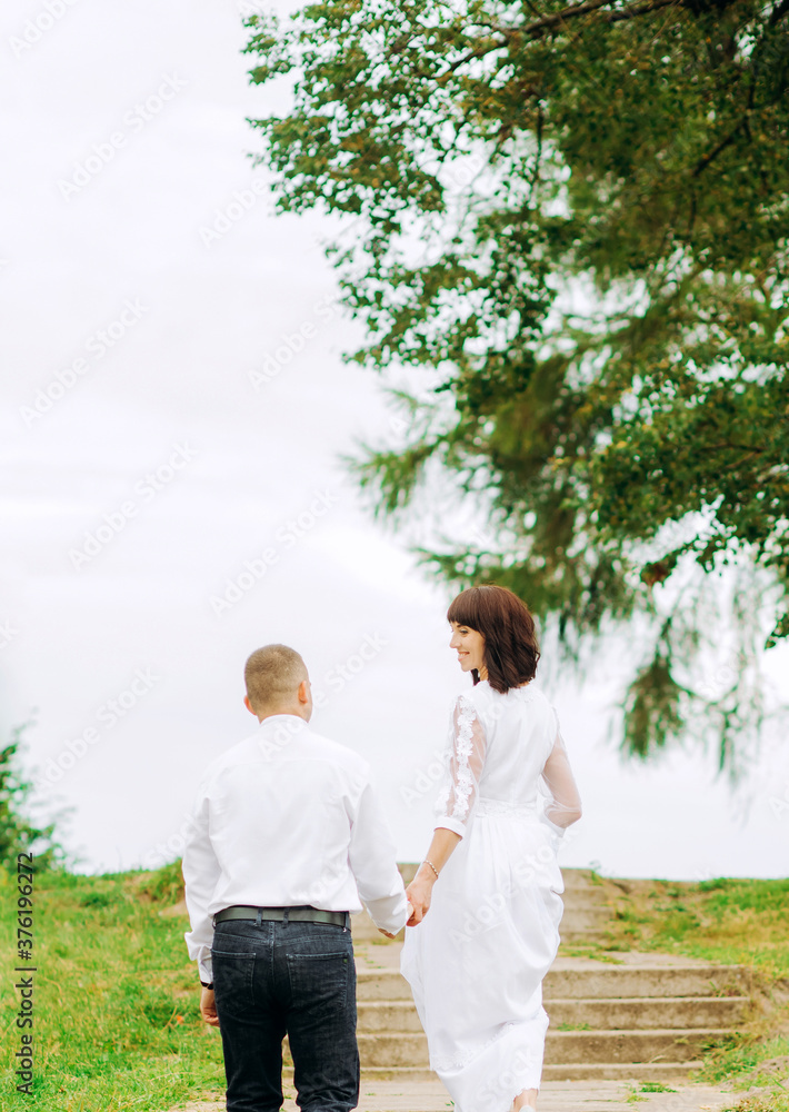 Beautiful wedding couple are walking in the park.