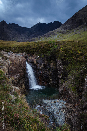 A waterfall in the Fairy Pools on the Isle of Skye under a stormy sky, Scotland, United Kingdom