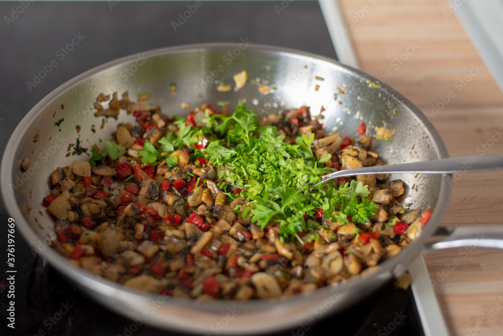 fried paprika and onions on a hot frying pan sprinkled with parsley, preparing a meal at home fried paprika and onions on a hot frying pan sprinkled with parsley, preparing a meal at home