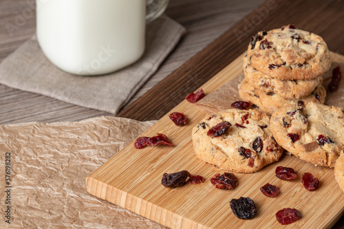 Home baked cookies on a wooden cutting board. Cookies with chocolate and cranberries