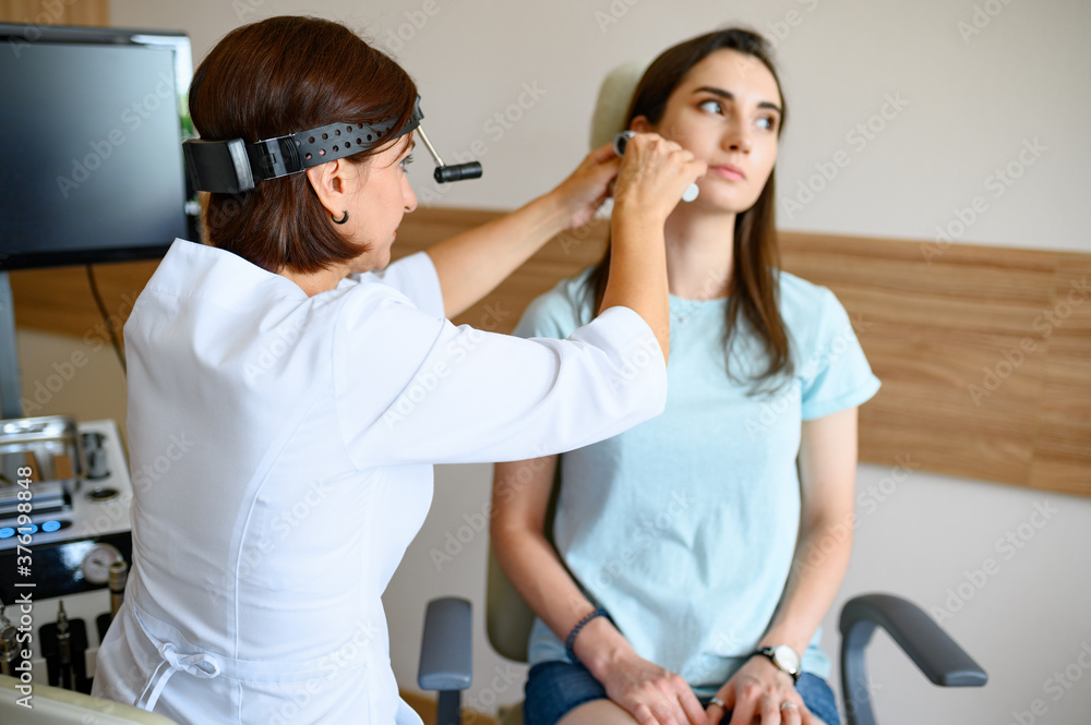 Female ent doctor and patient in office, ear exam Female ent doctor and patient in office, ear exam