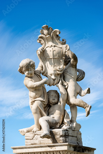 Putti fountain (Fontana dei Putti), Square of Miracles (Piazza dei Miracoli), Pisa, Tuscany, Italy. Three marble cherubs support the coat of arms of the city. Sculptor, Giovanni Antonio Cybei