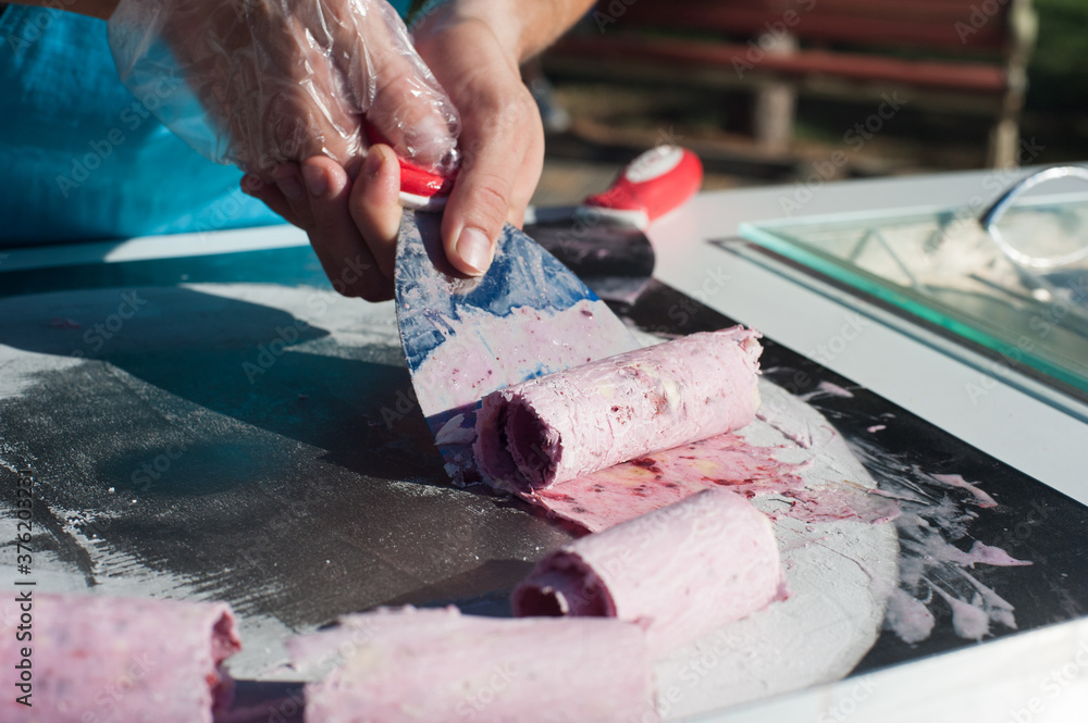 the chef makes a pink ice cream roll. Street sweets the chef makes a pink ice cream roll. Street sweets