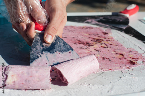 the chef makes a pink ice cream roll. Street sweets
