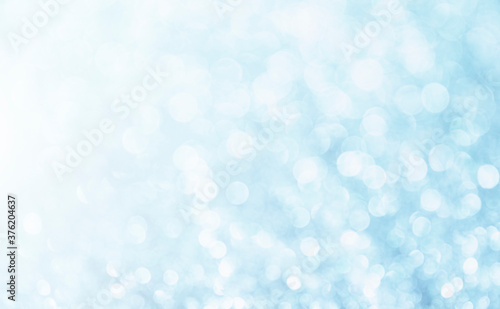 Blue background. White glitter blur vintage lights background. Bokeh silver and white. de-focused copy space.