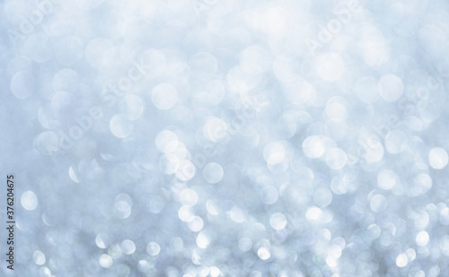 White glitter vintage lights background. Bokeh silver and white. de-focused copy space.