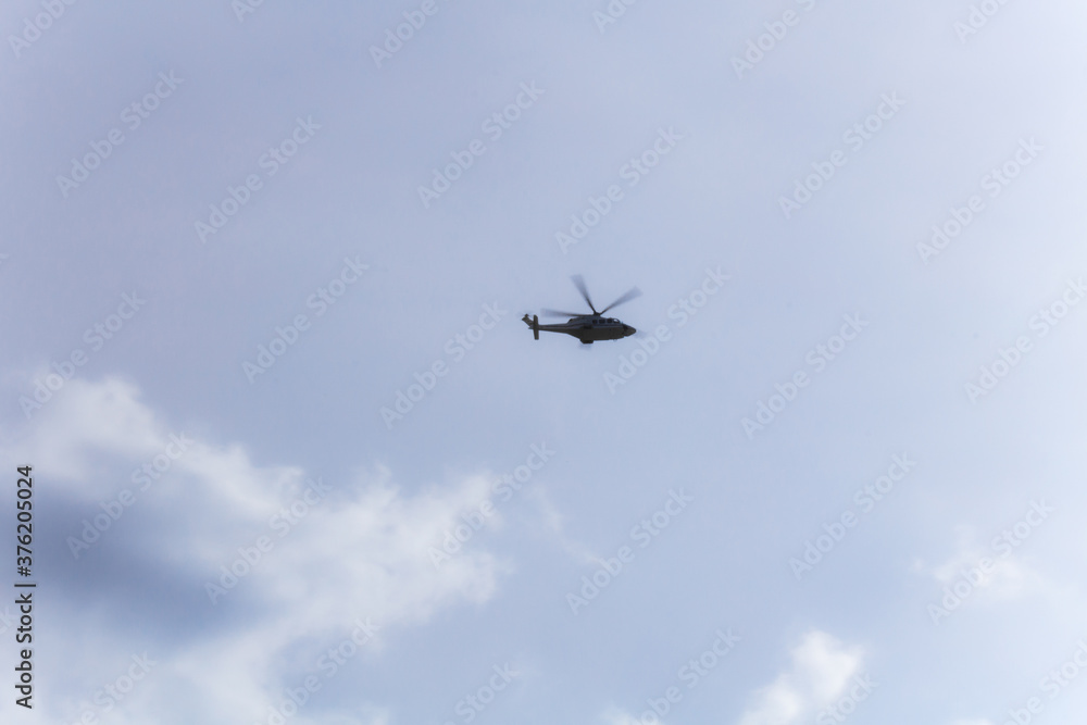 Helicopter in the distance in light sky with cloud. Soft focus. Helicopter in the distance in light sky with cloud. Soft focus.