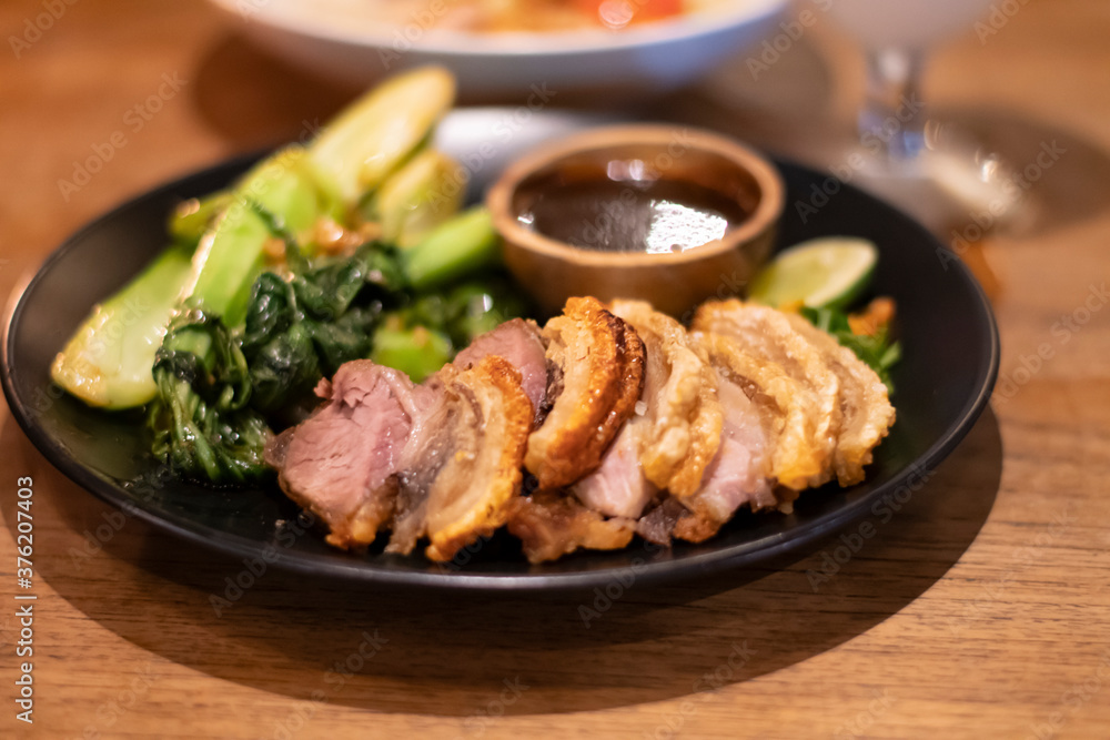 Freshly cooked dinner platter with nice decoration of crisp meat and green vegetables and sauce in a restaurant in Bali Freshly cooked dinner platter with nice decoration of crisp meat and green vegetables and sauce in a restaurant in Bali