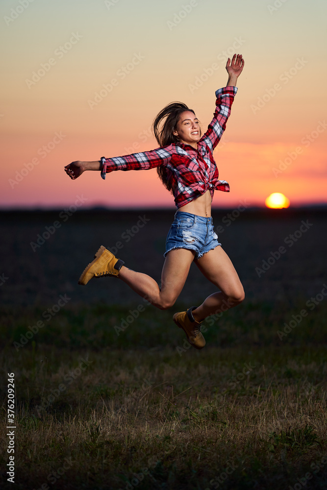 Young woman jumping for joy at sunset Young woman jumping for joy at sunset