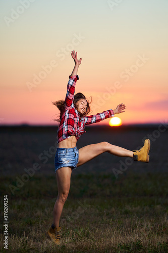 Young woman jumping for joy at sunset