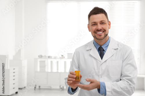 Professional pharmacist with pills in drugstore. Space for text