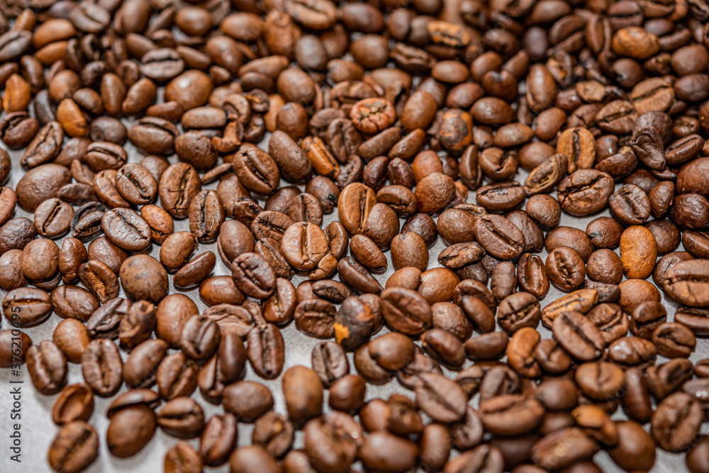 Geröstete Kaffee Bohnen Hintergund auf grauem Untergrund Geröstete Kaffee Bohnen Hintergund auf grauem Untergrund
