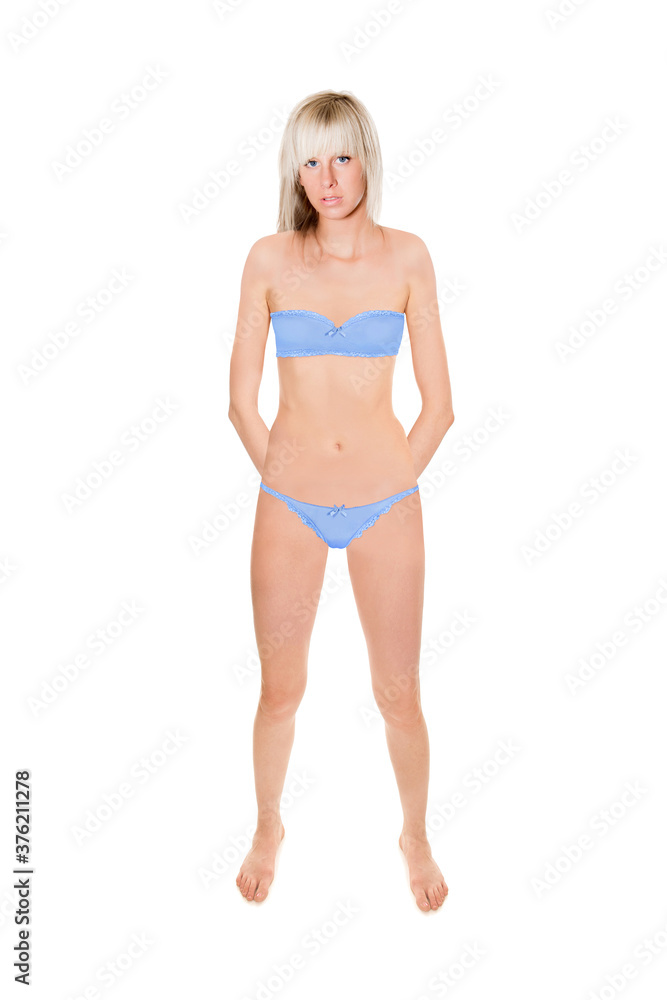 Attractive young blonde woman wearing blue bra and panties, full length portrait isolated in front of white studio background Attractive young blonde woman wearing blue bra and panties, full length portrait isolated in front of white studio background
