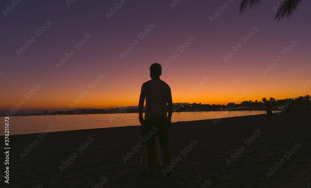 silhouette of a young man in the beach of Roses