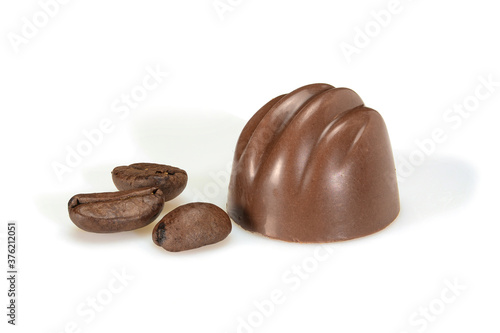 Chocolate pralines and coffee beans. Dark chocolate bonbon with coffee souffle, macro close up isolated on white background.