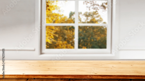 Blurred autumn window background and desk fo free space for your decoration 