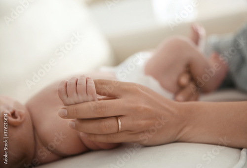 Mother with her newborn baby at home, closeup