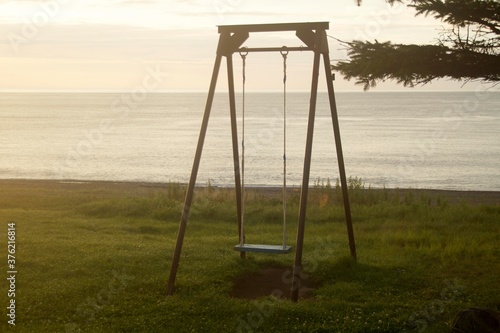 children's swing by the sea in the early morning