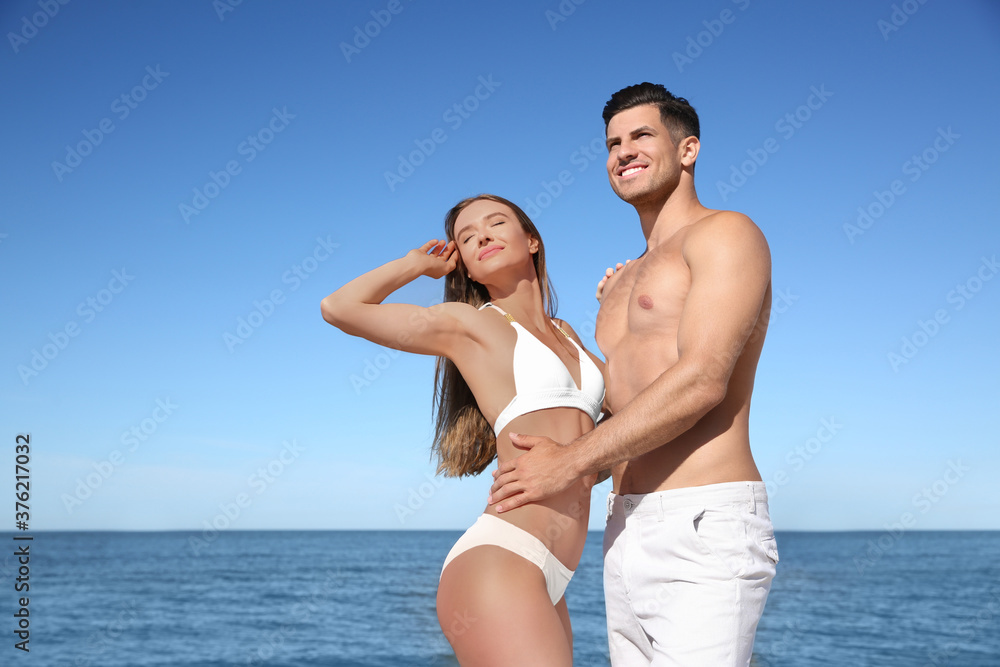 Woman in bikini and her boyfriend on beach. Happy couple Woman in bikini and her boyfriend on beach. Happy couple