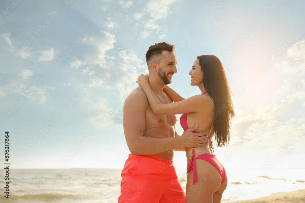 Happy young couple on beach on sunny day Happy young couple on beach on sunny day