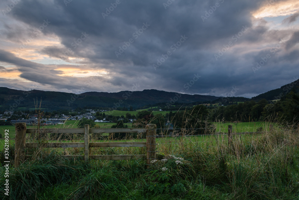 Scottish countryside with the village of Pitlochry in the background at a cloudy sunset, Scotland, United Kingdom