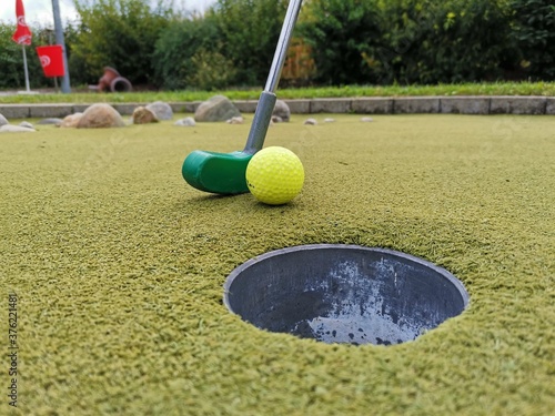 Golfschläger mit Ball beim Einlochen