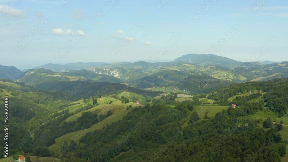 Aerial shot Serbia. drone flight in the mountains where you can see a small house surrounded by fields, forest, mountain peaks and beautiful landscape. Aerial shot Serbia. drone flight in the mountains where you can see a small house surrounded by fields, forest, mountain peaks and beautiful landscape.