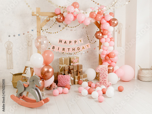 Birthday decorations - gifts, toys, balloons, garland and figure for little baby party on a white wall background. photo