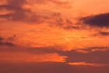Fire sky background. Soft clouds with the hint of the sun at sunset. Many orange tones and patterns of clouds.