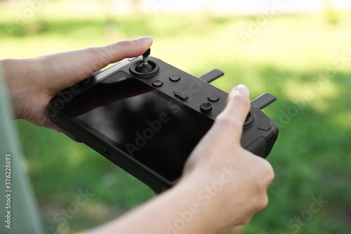 Woman holding new modern drone controller outdoors, closeup of hands