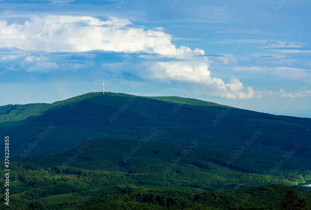 View of Kékestető mountain and the TV tower from Galyatető mountain. Summer landscape of the Mátra mountains in Hungary with beautiful clouds.