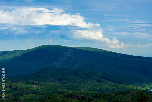 View of Kékestető mountain and the TV tower from Galyatető mountain. Summer landscape of the Mátra mountains in Hungary with beautiful clouds.