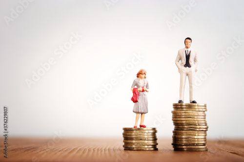 Conceptual image of gender inequality. A woman and a man with income difference photo
