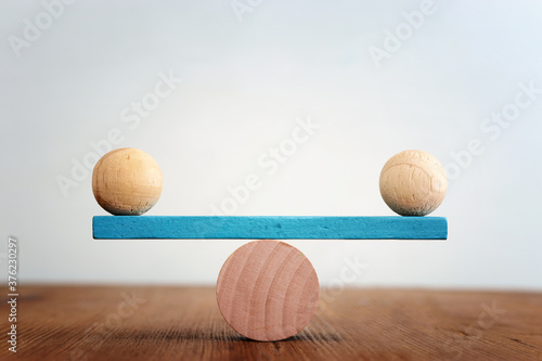 Fotografía Concept of finding the right balance. Wooden balls on seesaw