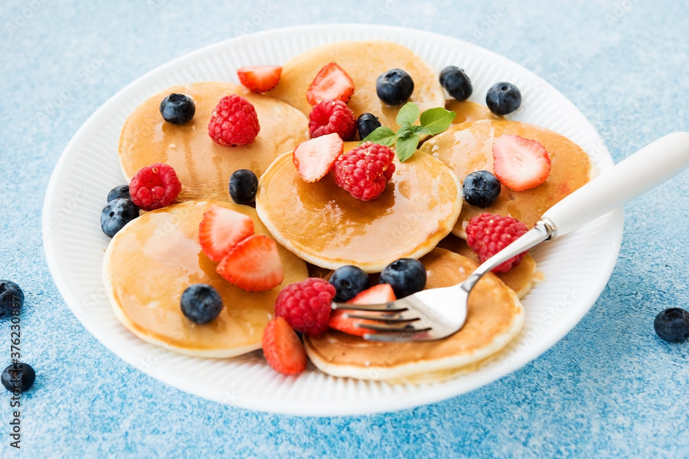 Close-up of American pancakes with honey and berries in a plate Close-up of American pancakes with honey and berries in a plate