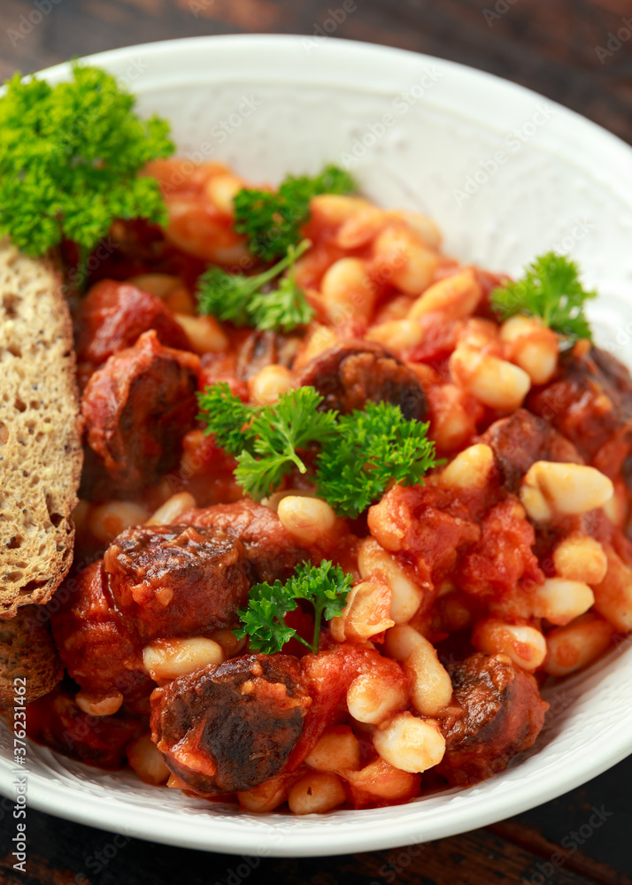 Bean and chorizo stew served in white bowl with parsley Bean and chorizo stew served in white bowl with parsley