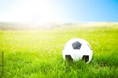 Soccer ball or football ball on ground and green field of grass