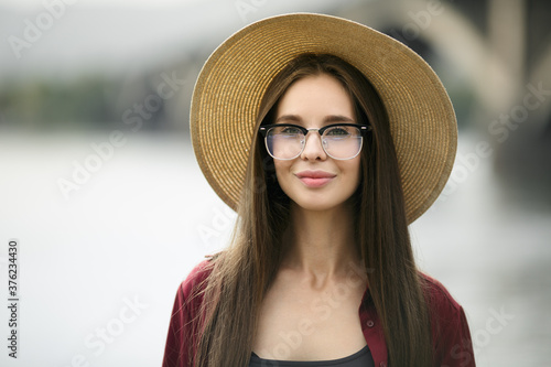 Portrait of a cute young woman wearing a hat and glasses. Urban style and fashionable clothes