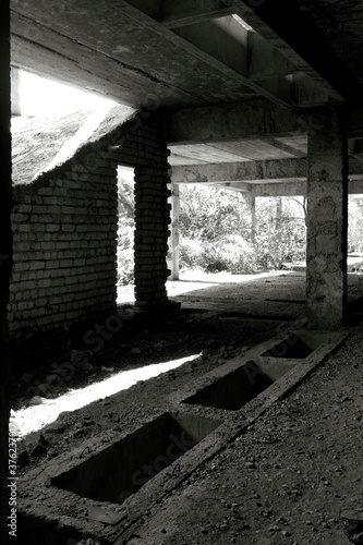 Unfinished and abandoned concrete and brick building. Unfinished construction with harsh sun light and shades. © Azazello