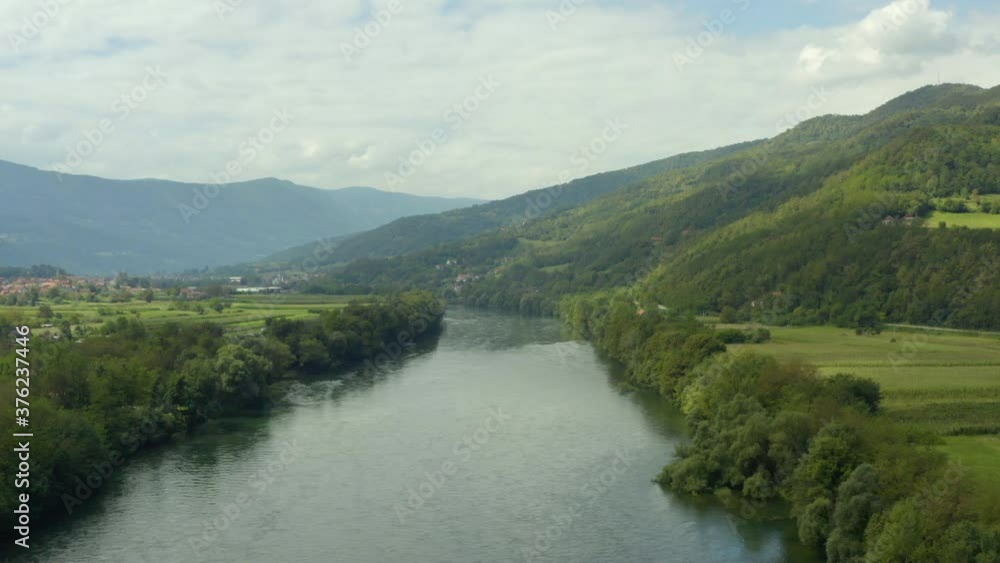 Aerial shot Serbia. Drone video of the river Drina flowing between the mountains where you can see forests, fields, houses, mountain peaks and landscape.
Aerial shot Serbia. Drone video of the river Drina flowing between the mountains where you can see forests, fields, houses, mountain peaks and landscape.