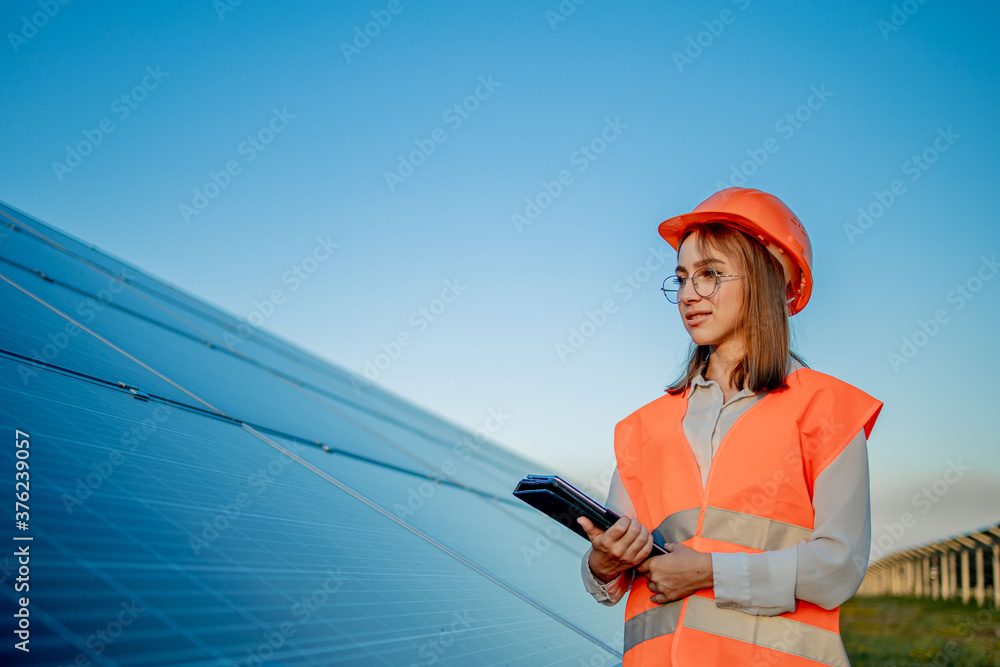 Inspector Engineer Woman Holding Digital Tablet Working in Solar Panels Power Farm, Photovoltaic Cell Park, Green Energy Concept Inspector Engineer Woman Holding Digital Tablet Working in Solar Panels Power Farm, Photovoltaic Cell Park, Green Energy Concept