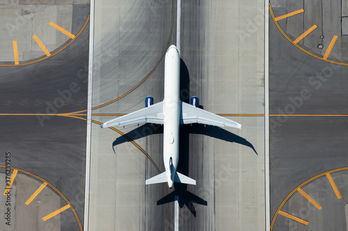 Fototapeta Aerial view of narrow body aircraft departing airport runway