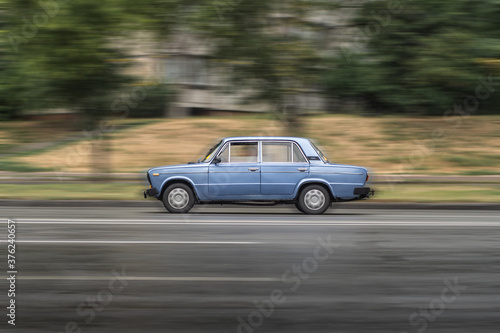Compact blue sedan car VAZ-2101 "Zhiguli" is in motion with motion blur. © Dmytro